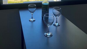 A table with a bottle and three glasses, overlooking a beach with palm trees and a clear sky. - Bel Appartement Moderne , Vue Océan Front de Mer, Plage, Nature, Détente (Tanger)