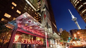 A hotel with a prominent sign reading "STAMFORD" and a view of the CN Tower in the background. - JW Marriott Auckland (Auckland)