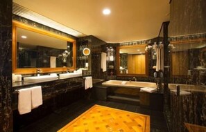 A luxurious bathroom with dark marble walls, multiple sinks, a large mirror, and a yellow patterned floor. - JW Marriott Auckland (Auckland)