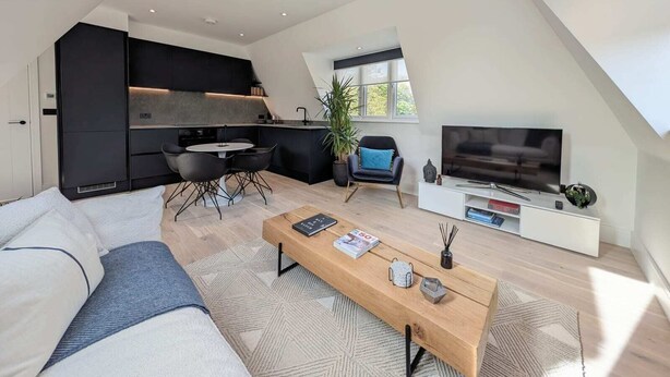 Un appartement moderne de style « loft » comprenant une cuisine, un coin repas et un salon.