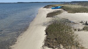 Ein Strand mit Kajaks und blauem Himmel.