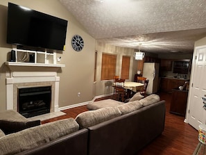 Relax in this stylish living room with a large flat-screen TV, comfortable sofa, and dining area.