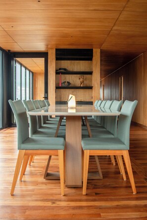 A conference room with a long table and matching chairs, wooden flooring, and a wooden ceiling. - Montefuego Samaipata (Samaipata)