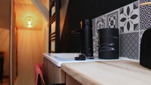 Una encimera de cocina con una cafetera, un hervidor y una botella de agua.