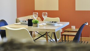 Un comedor con una mesa dispuesta para dos personas, que incluye un bol, un vaso y una pequeña planta en maceta.