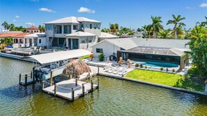 Une propriété située au bord de l’eau, dotée d’un quai, d’une piscine et d’une architecture moderne.