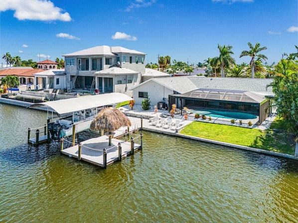 Une propriété située au bord de l’eau, dotée d’un quai, d’une piscine et d’une architecture moderne.
