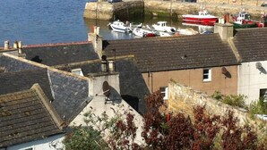 A coastal town with a marina, boats docked, and buildings with sloped roofs.