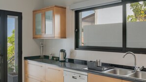 A modern kitchen with wooden cabinets, a dishwasher, and a sink. - Bay Bliss by Atlantic Holiday (Funchal)