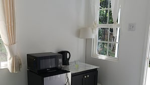 Eine kleine Küche mit Kühlschrank, Mikrowelle und Kaffeemaschine.