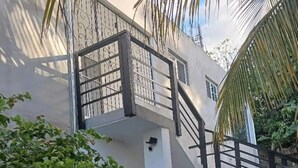 Ein mehrgeschossiges Gebäude mit Treppe und einer Palme.