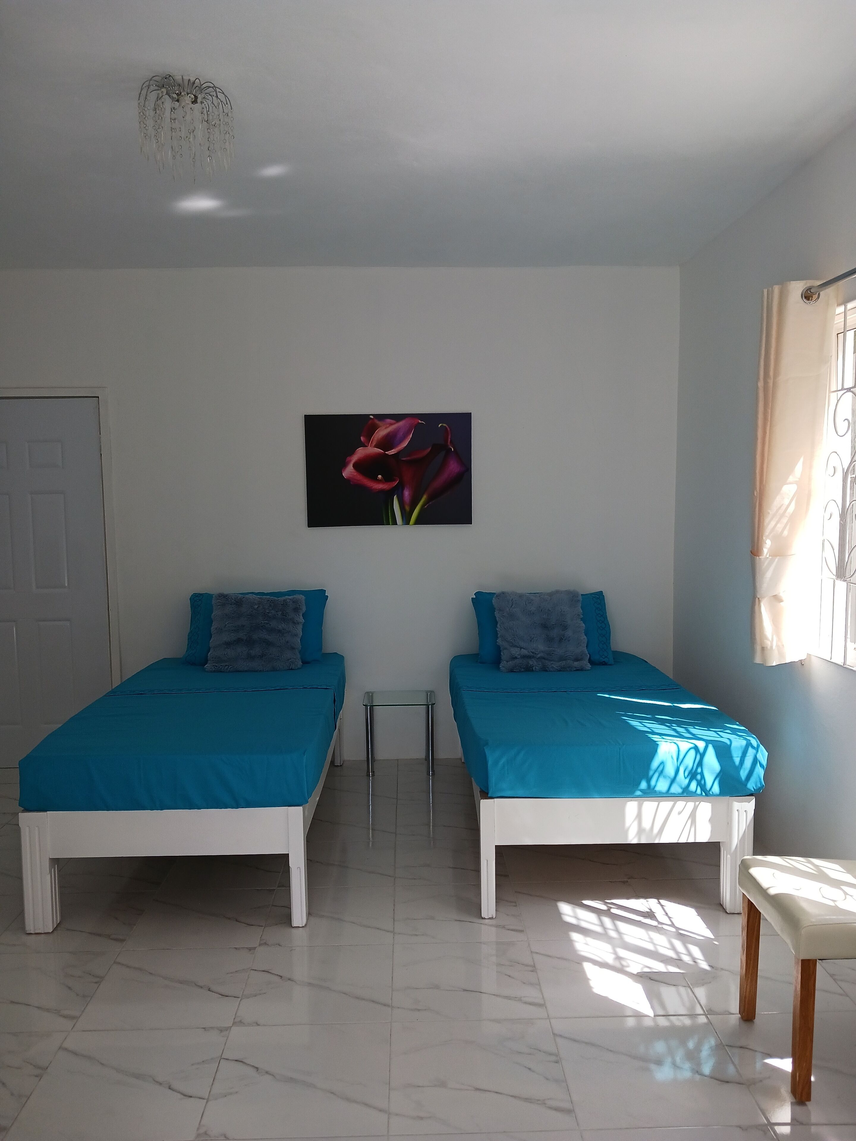 A room with two beds, a small table, and a chair.