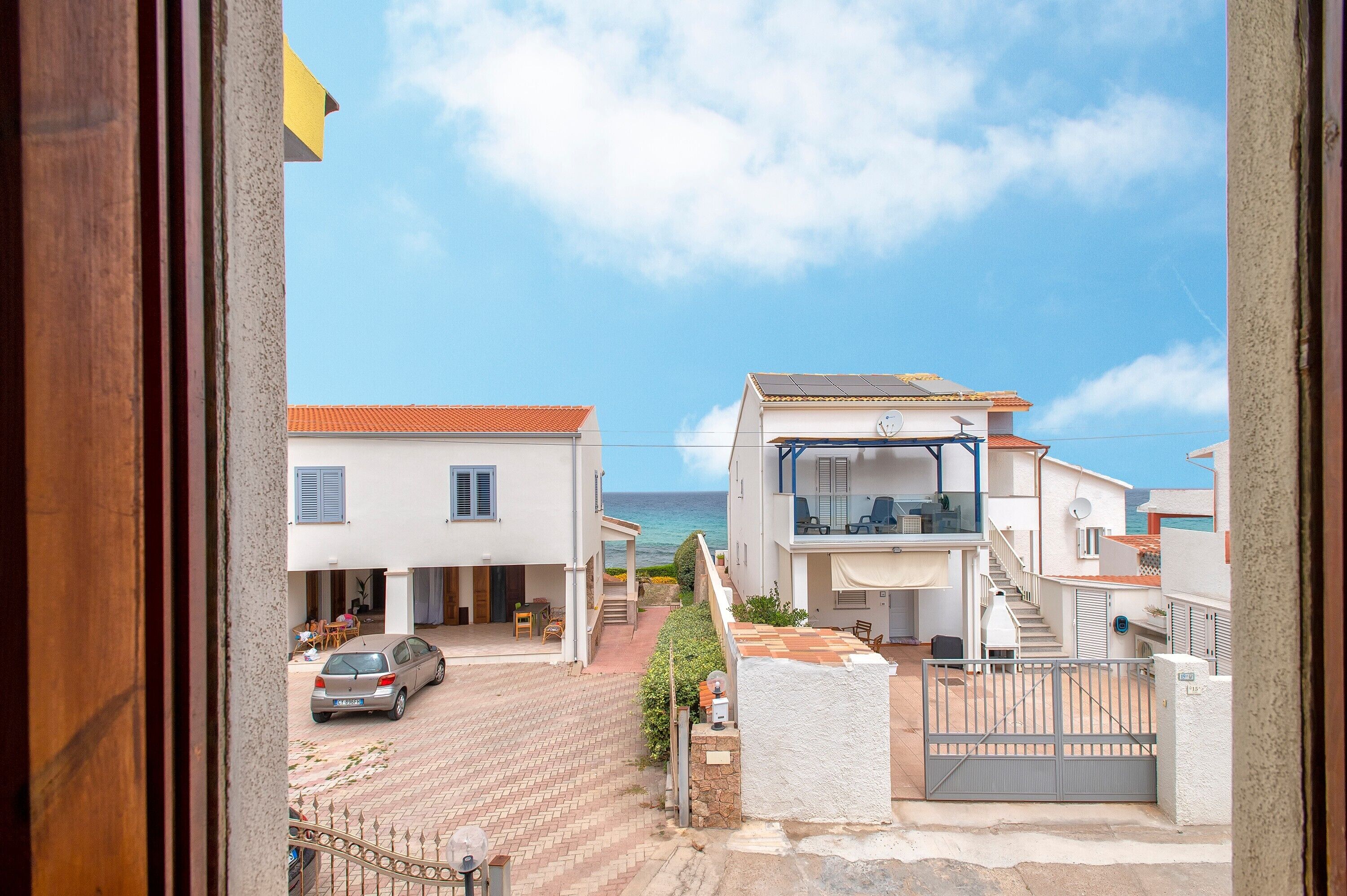 Zona residencial amb cases, una entrada pavimentada i una reixa.