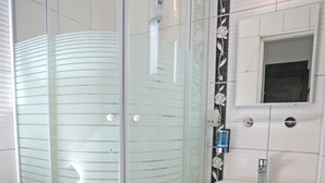 A bathroom with a glass-enclosed shower, a white sink, and a toilet. - Ömer Aybak Beach Hotel (Bodrum)