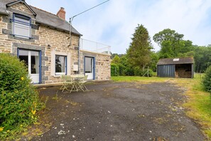 A stone house with a balcony, a small shed, and a gravel driveway. - Holiday Home 'La Maison Des Chevaux' with Private Terrace and Private Garden (Saint-Vran)