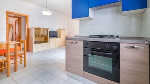 Une cuisine moderne équipée d’une cuisinière à gaz, d’un four et de meubles de couleur bleue.