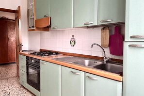 A kitchen with a gas stove, oven, sink, and cabinets. - SE091 - Senigallia, three-room apartment with balcony near the sea (Senigallia)