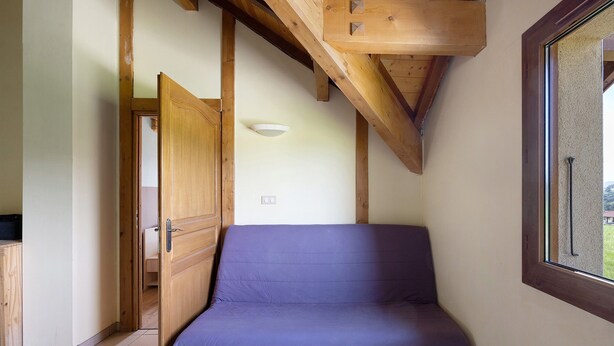 A room with a wooden ceiling, a purple mattress, a door, and a window. - Cottage 'Villa De St Off' with Mountain View, Private Terrace and Wi-Fi (Saint-Offenge)