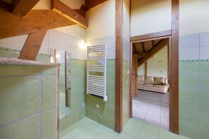 A bathroom with a shower, a towel rack, and a mirror.
