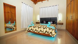 A bedroom with a bed, wooden wardrobe, and a mirror.