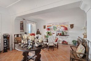 A dining area with a round table, chairs, and a variety of decorative items.