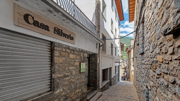 A narrow street with a building labeled 'Casa Silvestro' and a stone wall on the right. - Apartment 'Rural Ordiso' with Mountain View, Private Terrace and Wi-Fi (Torla-Ordesa)