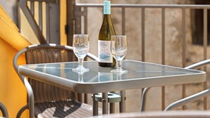 A glass table with a wine bottle and two glasses on it. - Apartment 'Rural Ordiso' with Mountain View, Private Terrace and Wi-Fi (Torla-Ordesa)