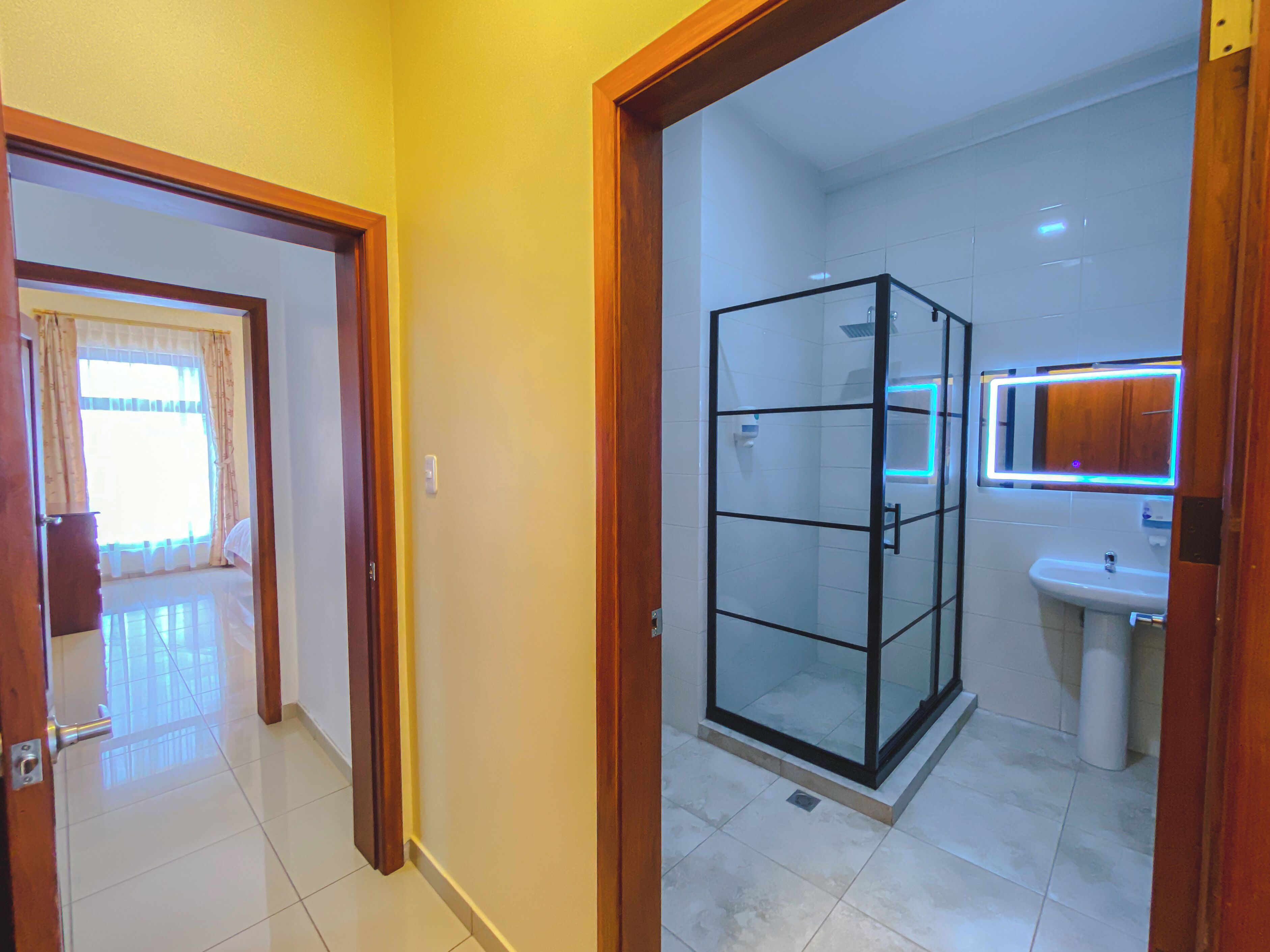 Un baño con cabina de ducha de vidrio, lavamanos y espejo.