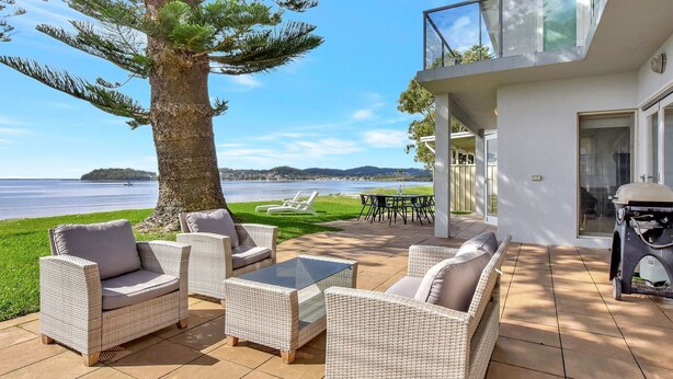 A patio with wicker furniture, a grill, and a view of the lake. - Filoli - A breathtaking waterfront (Salamander Bay)
