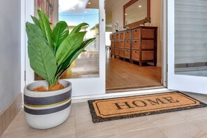 A potted plant, a doormat with 'HOME' written on it, and a wicker storage unit. - Filoli - Enjoy the calm waters of Salamander Bay (Salamander Bay)