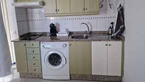 Cocina compacta con lavadora, lavaplatos y calentador de agua.