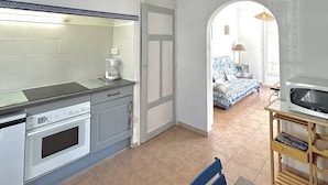 A compact kitchen with a coffee maker, oven, and a clock on the wall. - Pleasant village house close to the beach 4GSA12 (LE BARCARES)