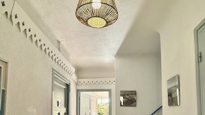 A hallway with a staircase, a hanging light fixture, and a door leading to an outdoor area. - Pleasant village house close to the beach 4GSA12 (LE BARCARES)