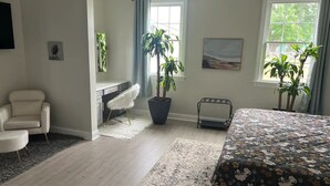 A bedroom with a bed, a desk, a chair, and two potted plants. - The Hoosier House! An entire property experience! (Indianapolis)