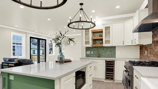 A modern kitchen with white cabinetry, a large island, a built-in oven, and a gas stove. - The Hoosier House! An entire property experience! (Indianapolis)