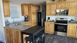 Eine moderne Küche mit Holzschränken, Granit-Arbeitsplatten und Edelstahlgeräten.
