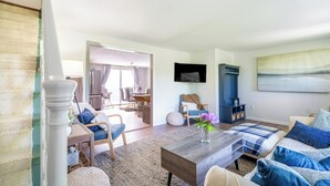A modern living room with a sofa set, a coffee table, and a TV mounted on the wall. - Perfect for Multiple Families- Close to Beach, Trails, Wineries, Breweries (South Haven)