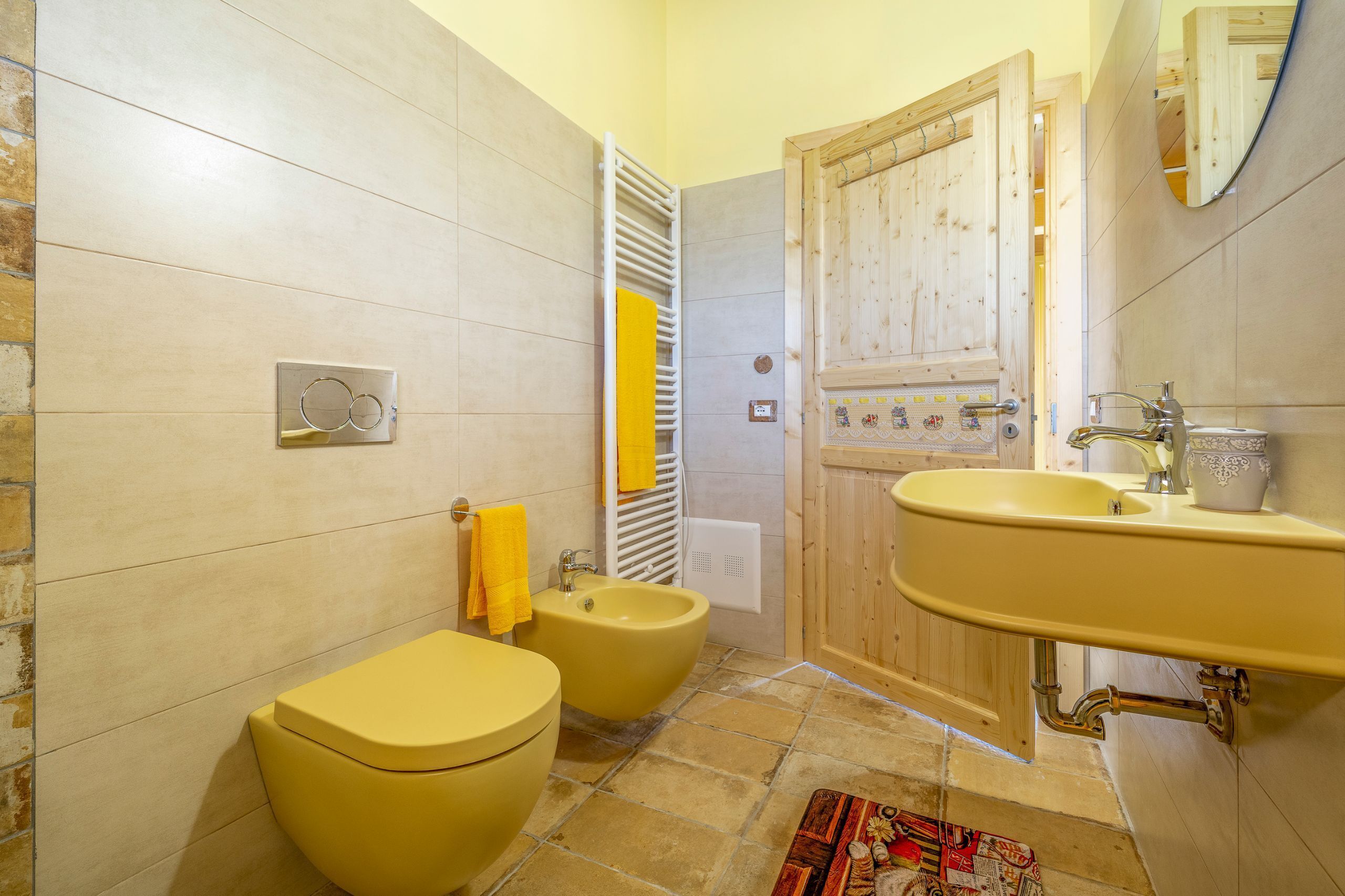 Un baño con un lavabo amarillo, un bidé y un inodoro.