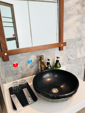 A bathroom with a black sink, a mirror, and a towel rack. - zhuiyikezhan (Zhangjiajie)