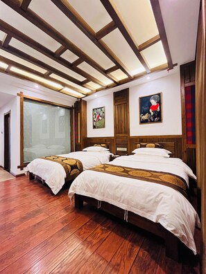 A hotel room with wooden flooring, two beds with white linens and brown headboards, a large window with a view, and wooden ceiling beams. - zhuiyikezhan (Zhangjiajie)