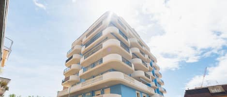A multi-story building with balconies and a blue facade.