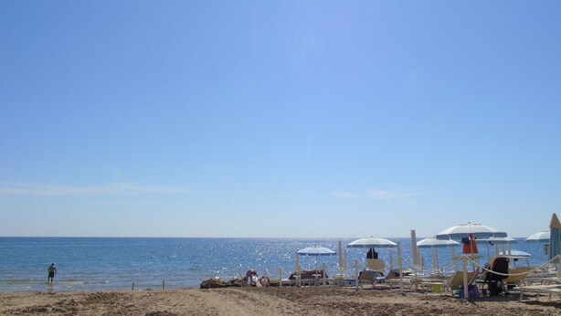 A beach with umbrellas and lounge chairs, a clear sky, and the ocean. - Homiday - Felicioni Alba Adriatica, Bilocale al Piano Terra (Alba Adriatica)