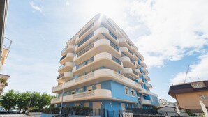 A multi-story building with balconies and a blue facade. - Homiday - Felicioni Alba Adriatica, Bilocale al Piano Terra (Alba Adriatica)