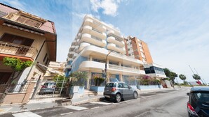 A multi-story residential building with balconies, a gated entrance, and a street view. - Homiday - Felicioni Alba Adriatica, Monolocale al 1°piano (Alba Adriatica)