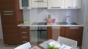 Une cuisine moderne avec des meubles en bois, un four encastré et un évier en acier inoxydable.