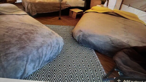 Une pièce ressemblant à une tente, avec un lit, une petite table et une chaise.