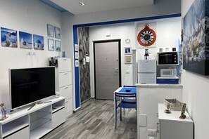 Una cuina compacta amb televisió, microones i nevera.
