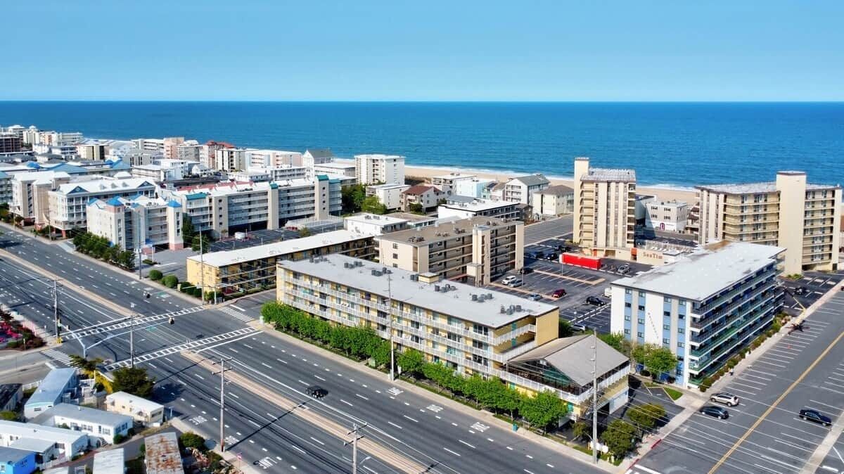 A coastal cityscape with a beachfront hotel, wide roads, and clear skies.