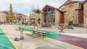 A building with stone walls, a large entrance, outdoor seating, and a green bike lane. - Ski in, ski out resort at Grand Timber Lodge in beautiful Breckenridge, CO (Breckenridge)