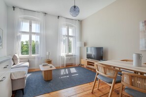 Relax in a spacious living area with a sofa, flat-screen TV, and dining table.